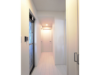 玄関から繋がる廊下を白にして清潔感と広がりを