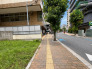緑豊かな街路樹が心地よい風情を添え、落ち着いた日常が流れる住環境の風景です。