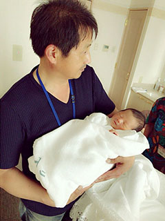 赤ちゃんを抱く松兼